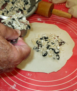 Filling is measured onto the calzone dough rounds before sealing.