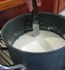 The curd is sliced into cubes with a long knife or spatula.