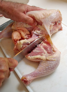 Carefully feel for the thigh joint, then cut through it to remove the leg.
