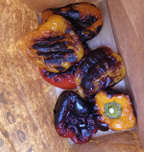 Peppers are put in a closed paper bag hot off the grill. The steam will loosen the skin so it slips off when they are cooled.