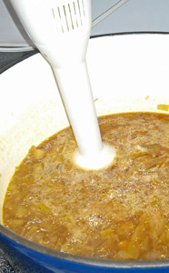 The soup is pureed in the pot using an immersion blender.